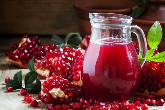 Pitcher with fresh pomegranate juice, selective focus