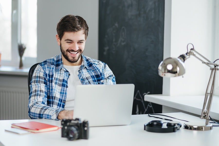 young man sitting in office and using laptop computer